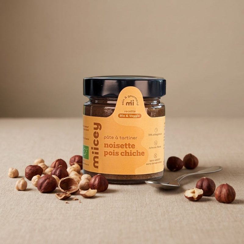 Pot de pâte à tartiner bio MIICEY Noisette et pois chiche, entouré de noisettes et de pois chiches.
